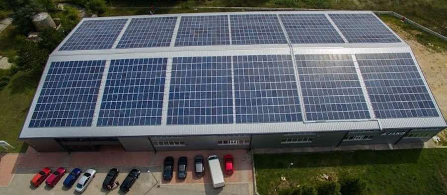 Luftaufnahme eines langen Gebäudes mit vielen Solarzellen auf dem Dach